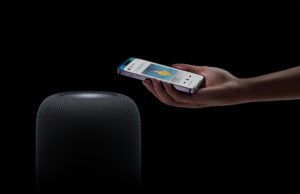 Apple HomePod 2nd Generation with iPhone being held close to it.