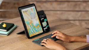 Apple iPhone and iPad on a stand with a person typing on a keyboard.