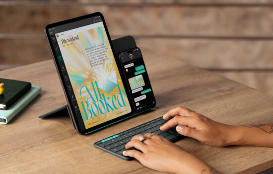 Apple iPhone and iPad on a stand with a person typing on a keyboard.