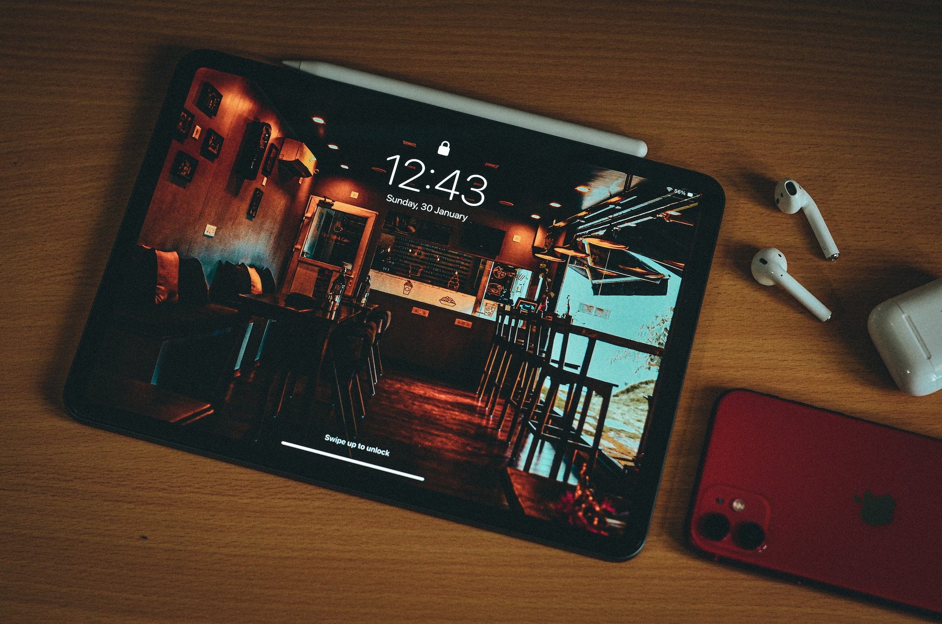 iPad on a table with AirPods and iPhone.
