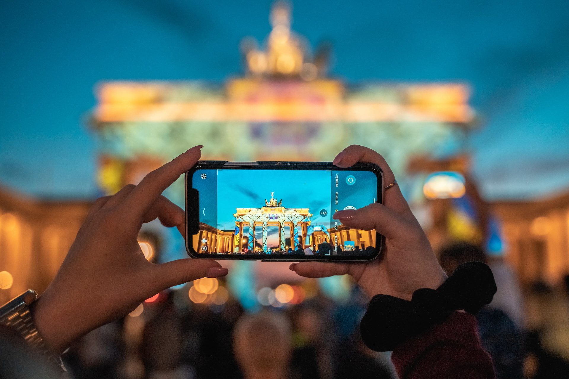Woman taking photo of a landmark on iPhone.