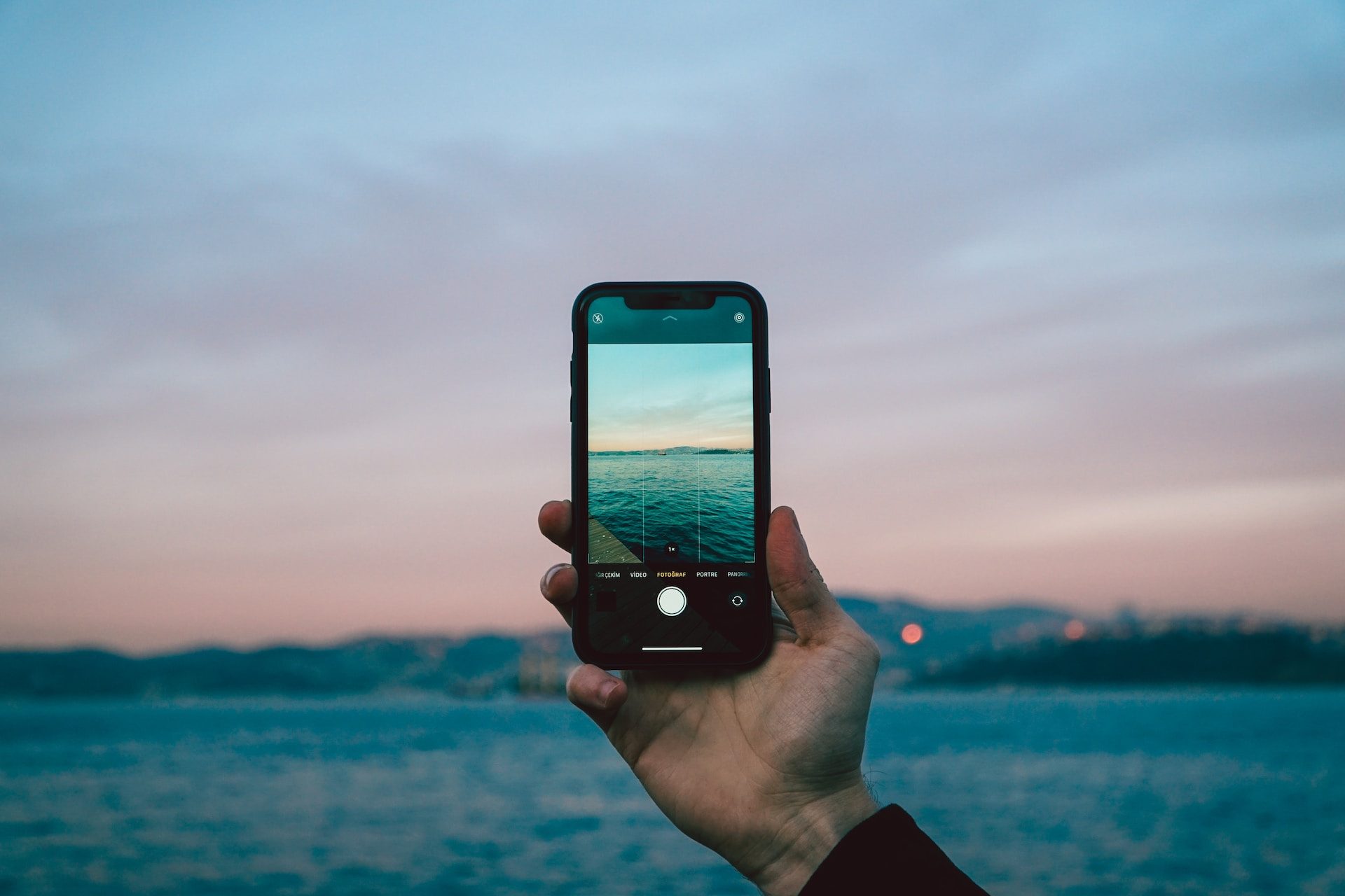 Man holding iPhone with the camera app open.
