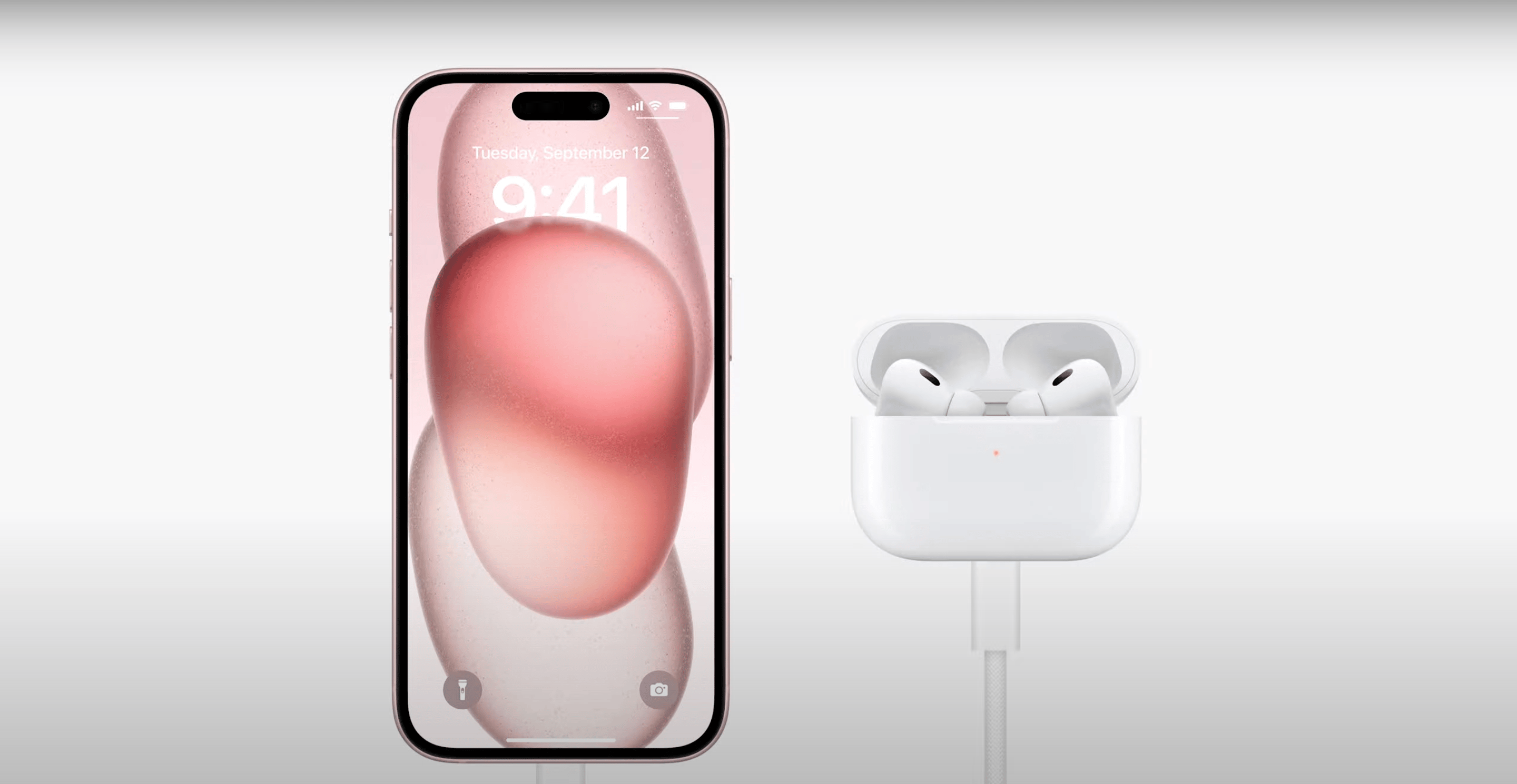 iPhone 15 charging with a USB-C cable a second gen AirPods Pro.