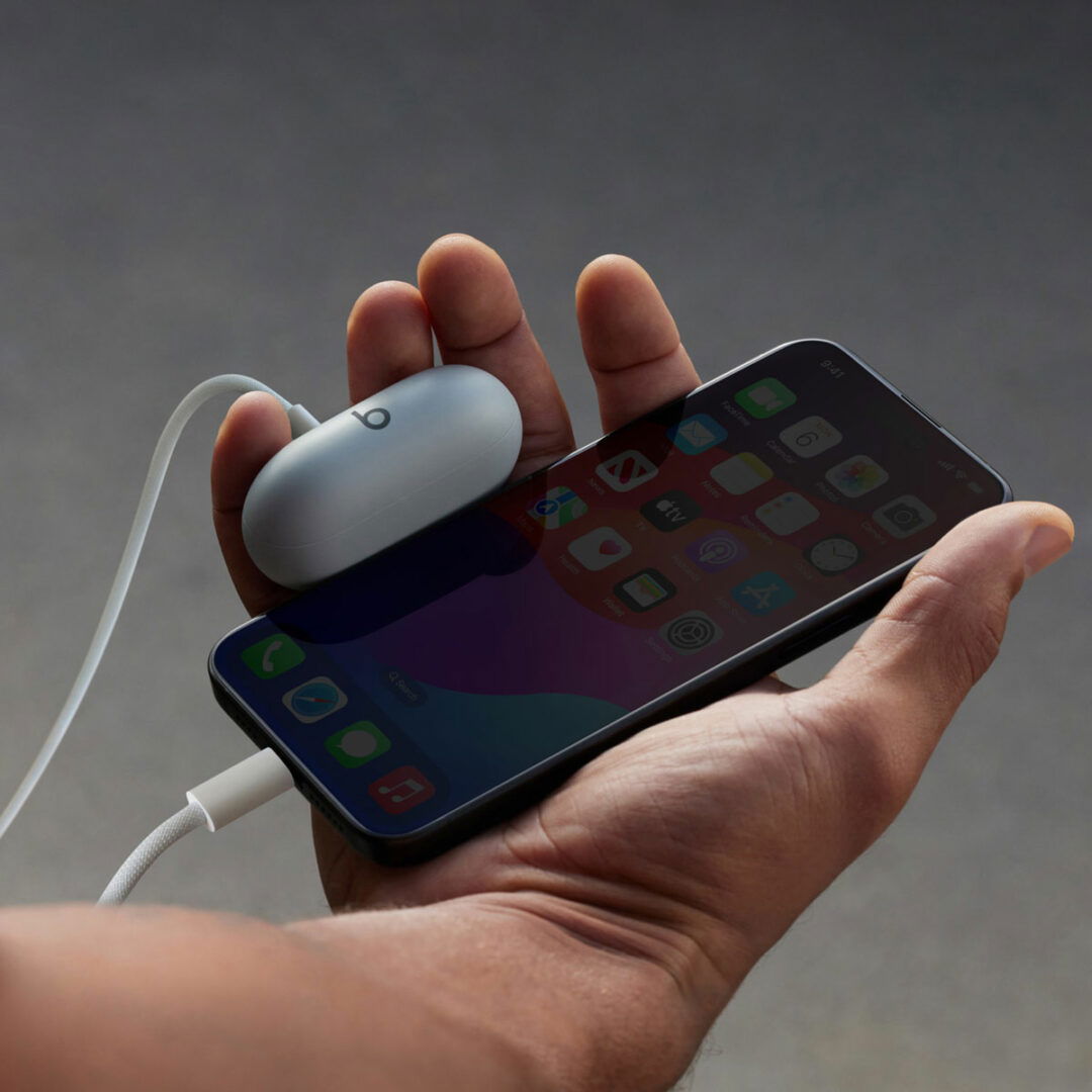 iPhone 15 model charging a Beats Solo Plus via USB-C